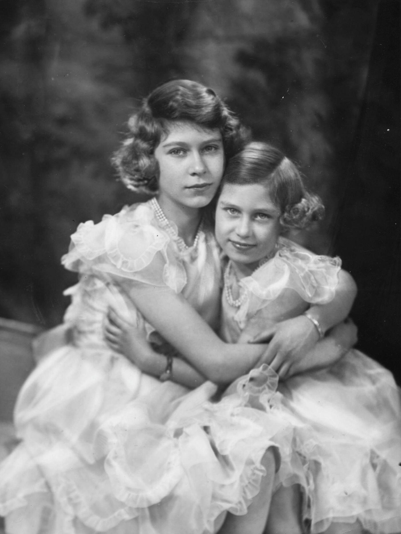 Princesses Elizabeth and Margaret with their arms around each other, 1939.