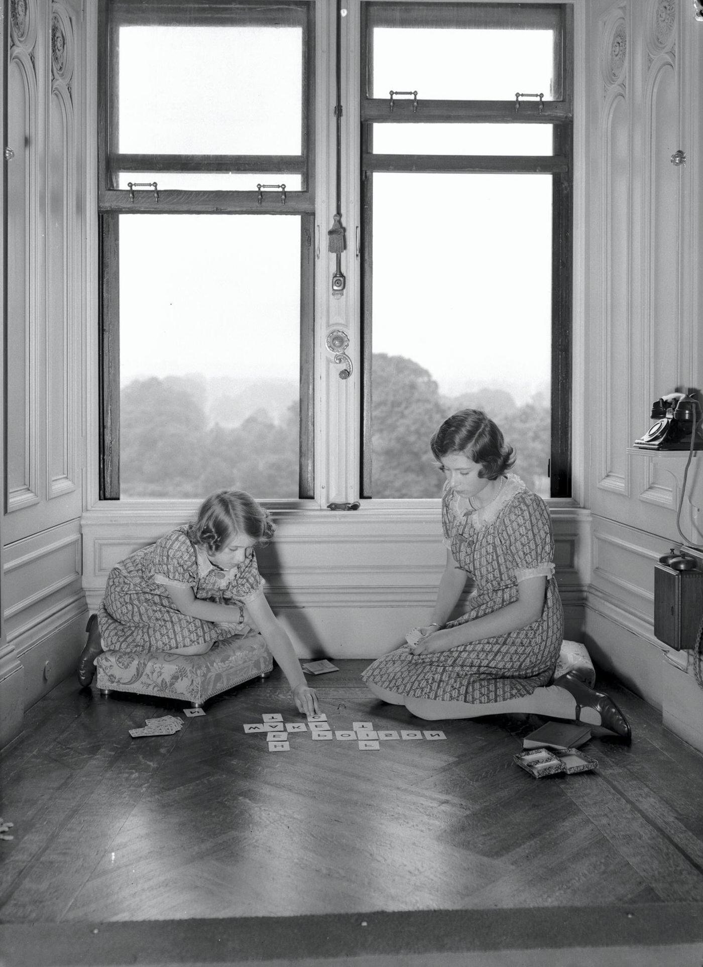 Princess Margaret (1930-2002, left) and Princess Elizabeth playing the word card game Lexicon, at Windsor Castle, Berkshire, Great Britain, 22nd June 1940.
