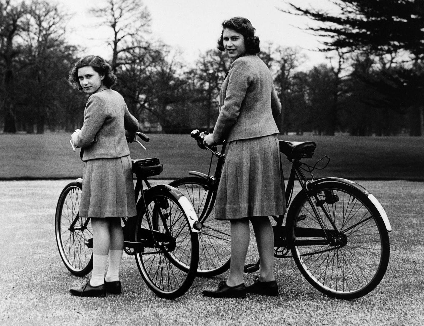 Princess Elizabeth and Princess Margaret prepare to set off for a bicycle ride at Windsor Royal Lodge.