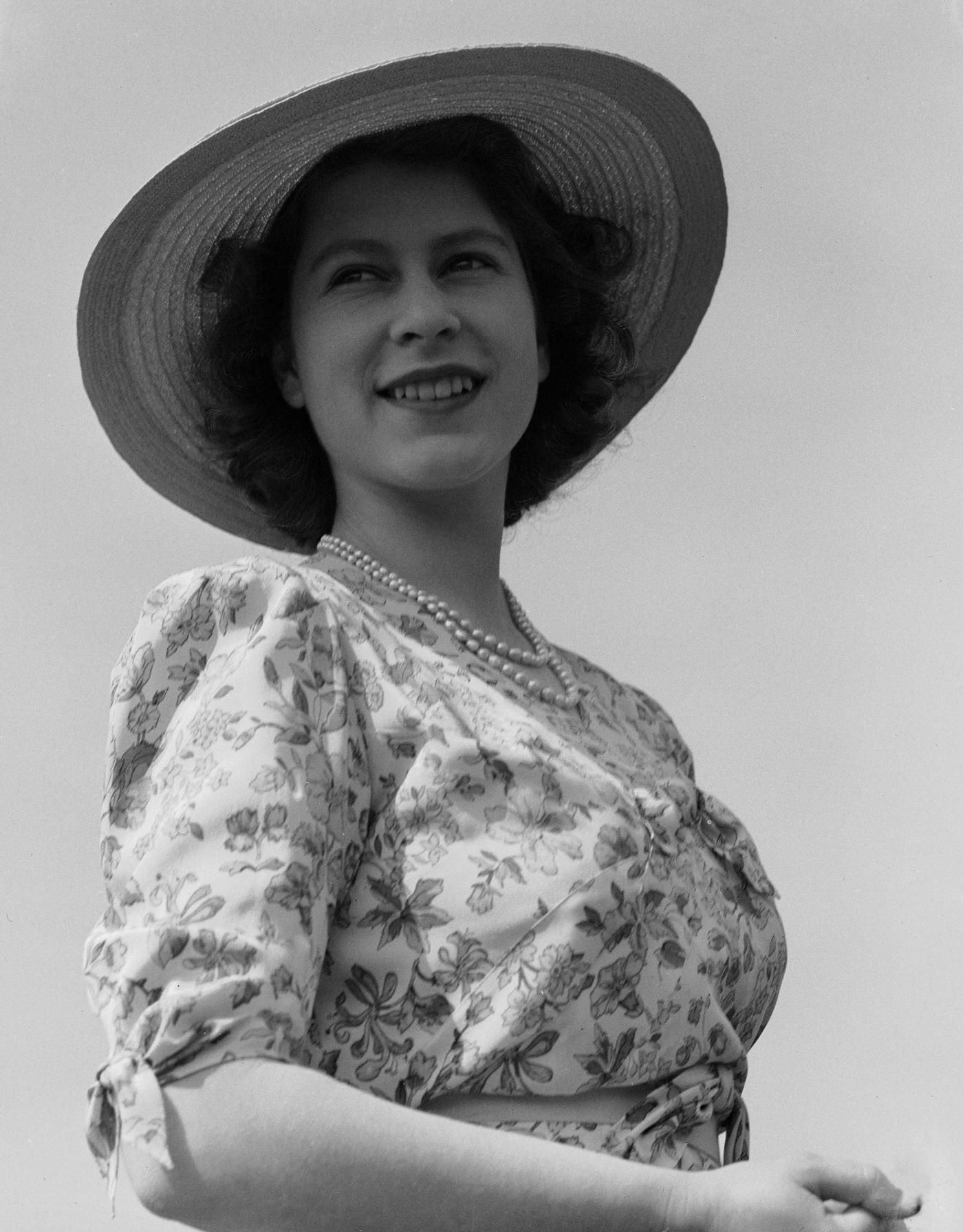 Princess Elizabeth wearing a summer dress and sunhat in the grounds of Windsor Castle, 1944
