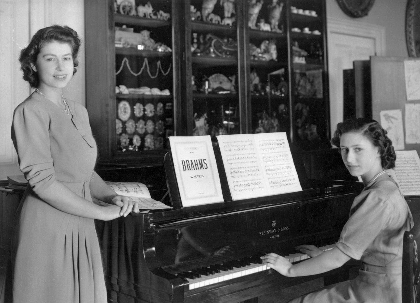 Princess Elizabeth and Princess Margaret Rose at a piano in the school room of Buckingham Palace, London, 19 July 1946.
