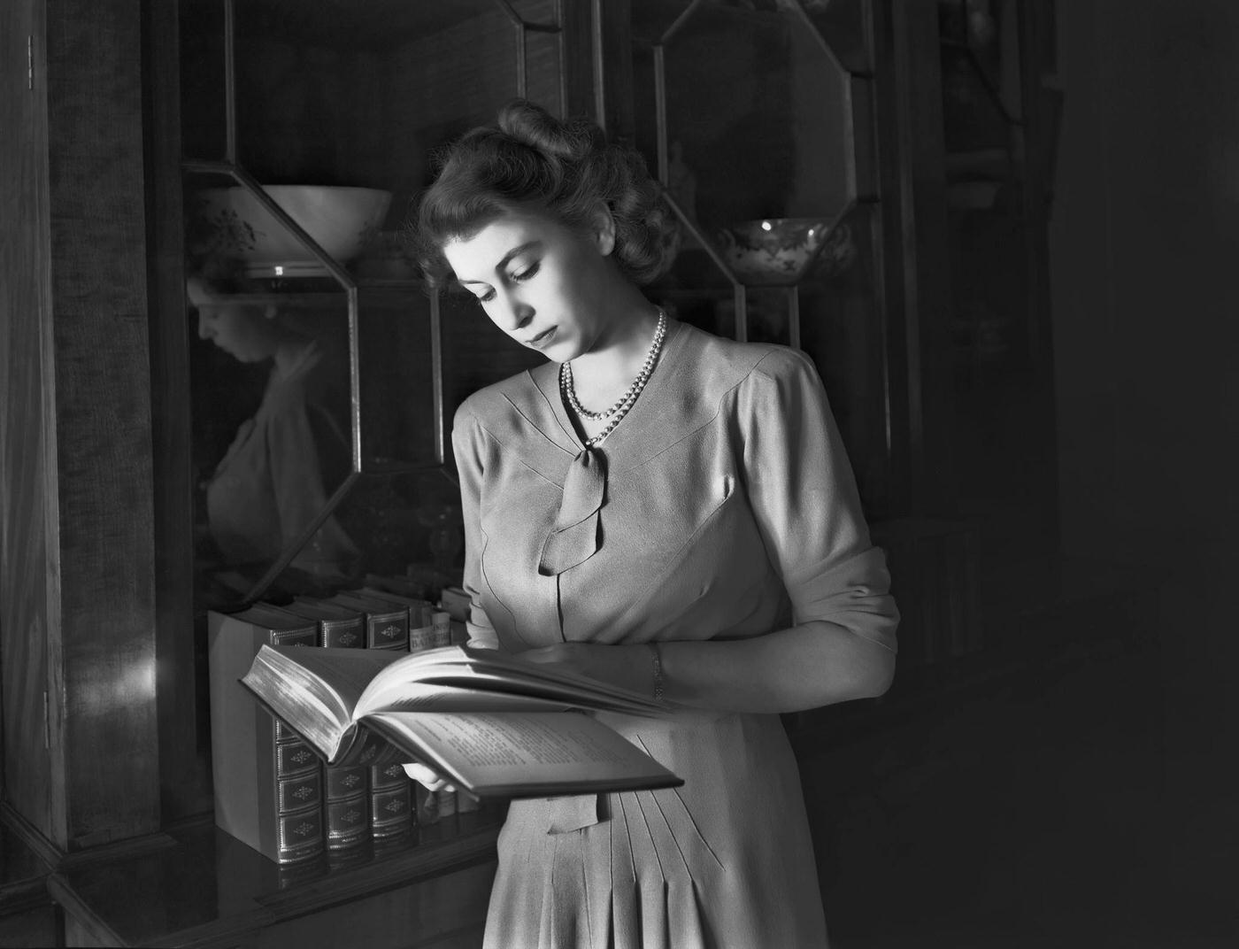 Princess Elizabeth reading a book at Buckingham Palace, London, 19 July 1946.