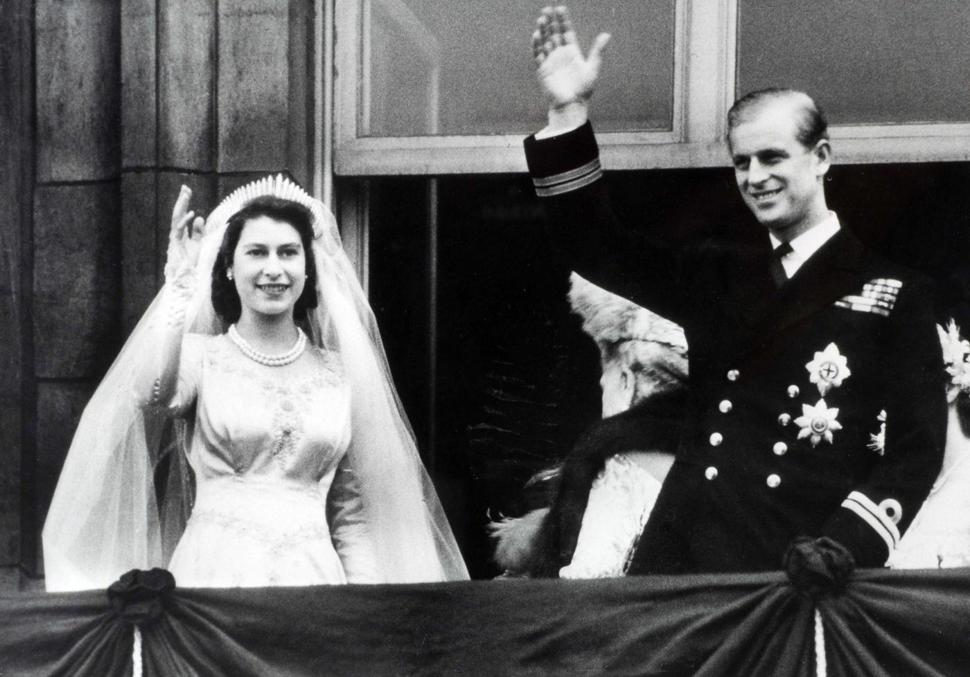 Princess Elizabeth (now The Queen) and Prince Philip, The Duke of Edinburgh, wave to crowds from the balcony of Buckingham Palace following their marriage, London, England, 20 November 1947.