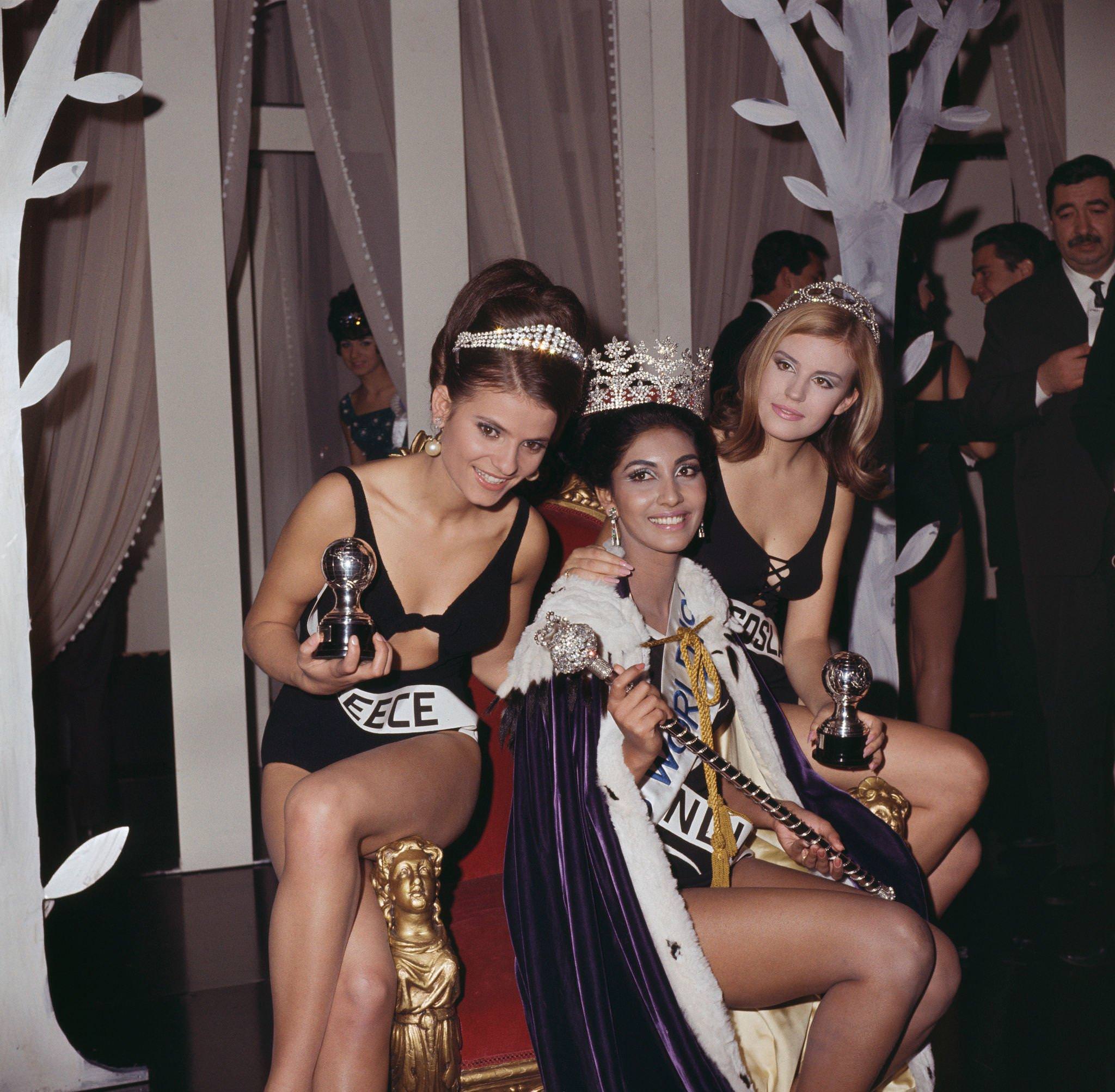 Winner of Miss World 1966, Reita Faria of India wears her crown and sits on the winner's throne with runners-up.
