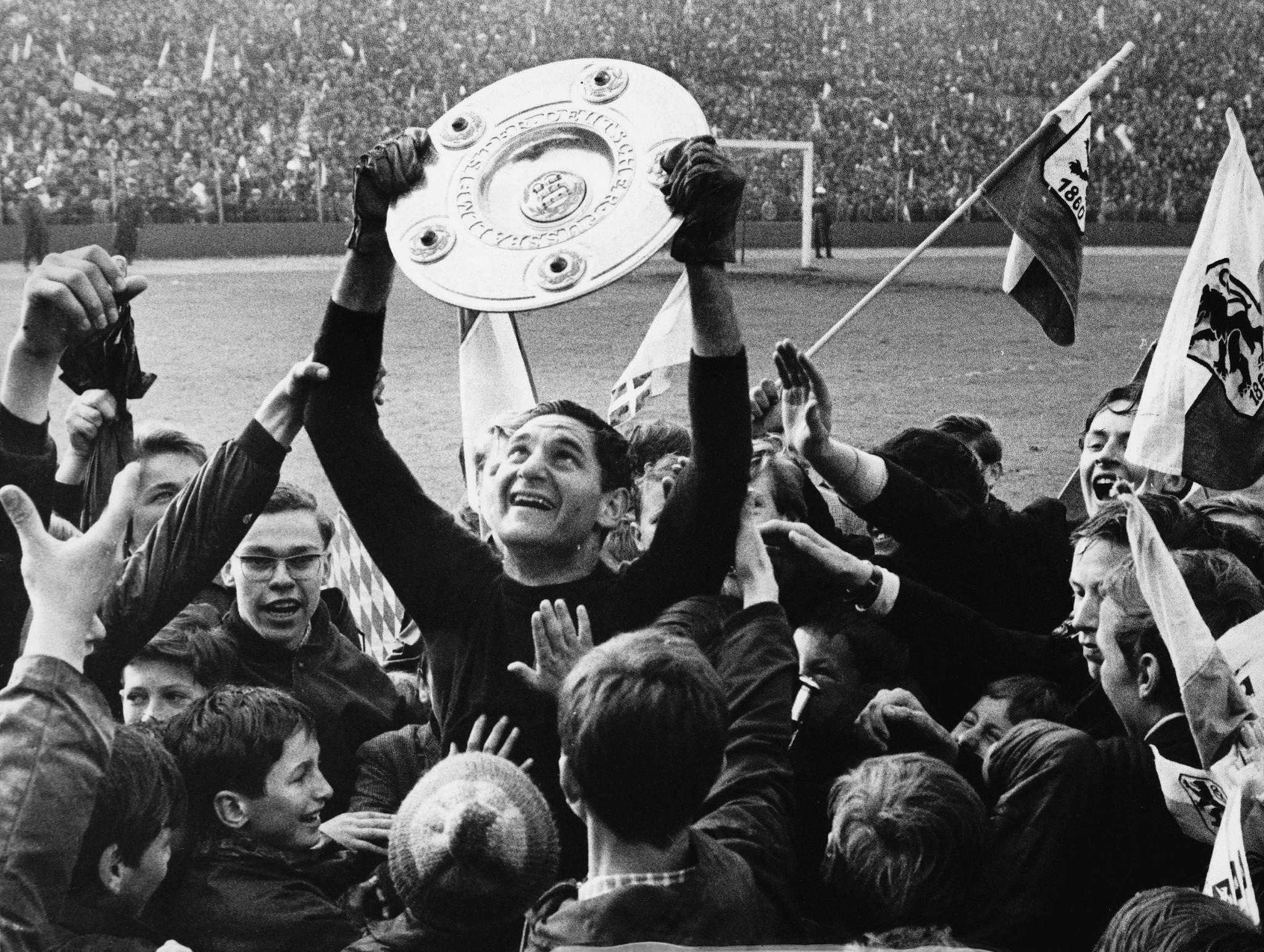 Petar Radenkovic, goalkeeper for TSV 1860 Munich, celebrates with fans holding up the winner's cup after a 1-1 draw against HSV to become German football champion, 1966