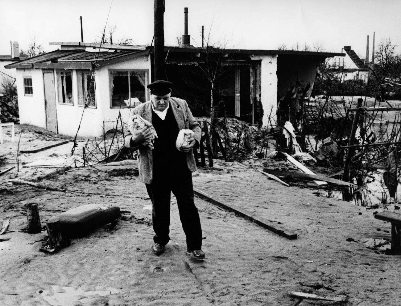 Man standing in front of a destroyed house during the North Sea flood of February 1962 in Hamburg, West Germany