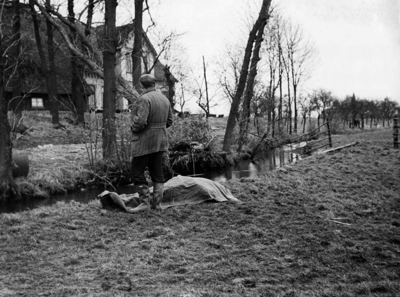 Man standing next to a corpse during the North Sea flood of 1962 in Hamburg, West Germany