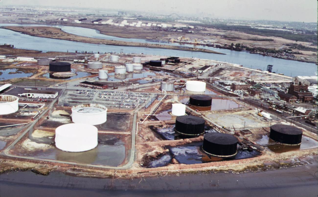 American cyanimid and bp storage tanks on the new jersey side of arthur kill, with gulf oil tanks on staten island in background, 1970s