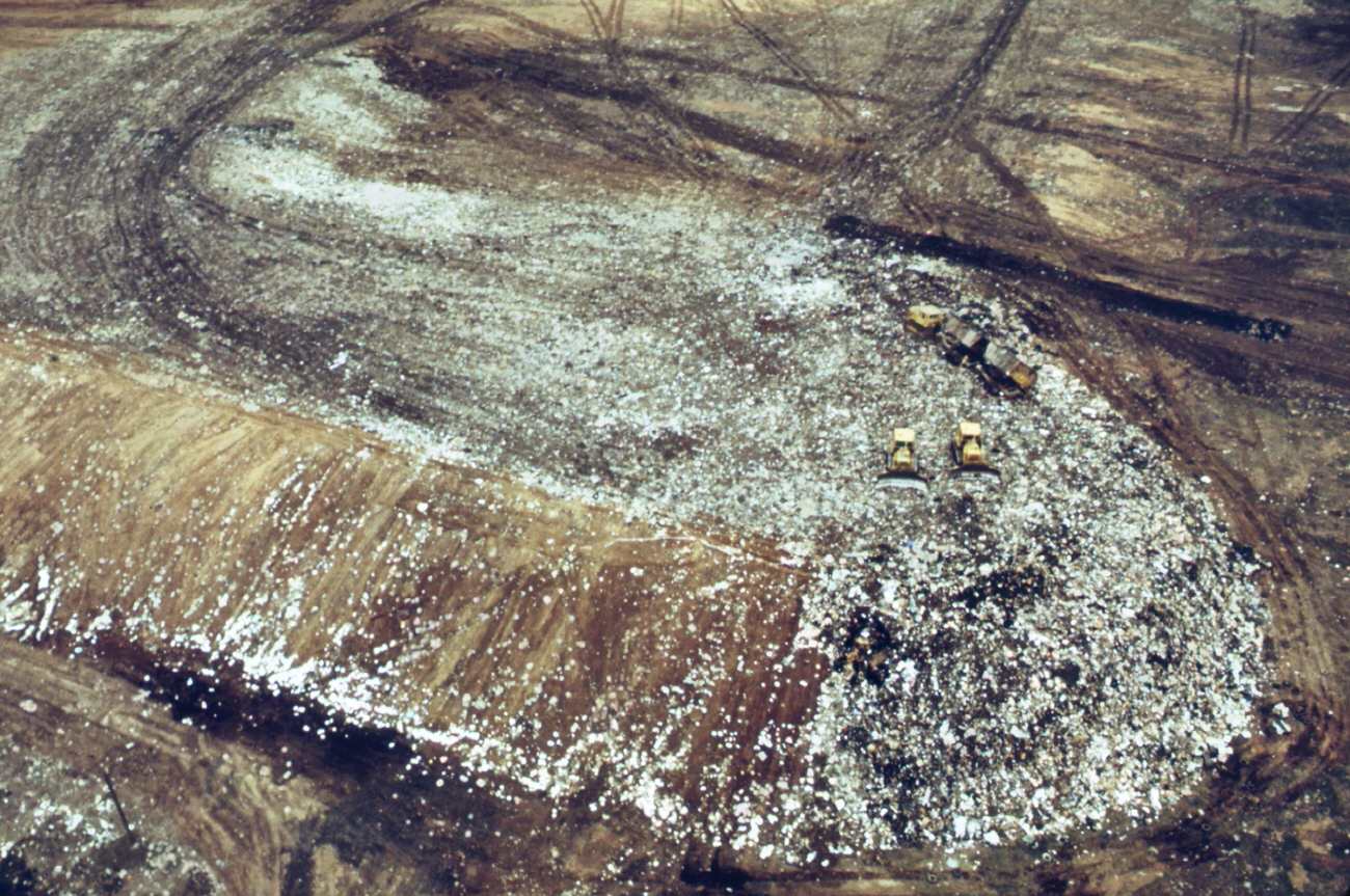 Solid waste covers land at fresh kills on staten island heavy tire tracks are left by trucks used in hauling waste from docks, 1970s