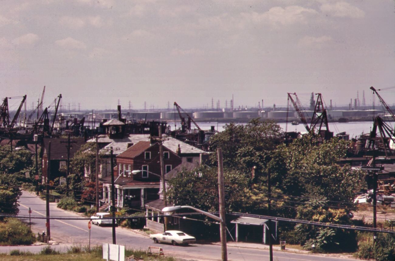 Arthur kill road in staten island, looking south. Private houses are almost engulfed by encroaching industries. In background is the arthur kill and the new jersey shore, 1970s