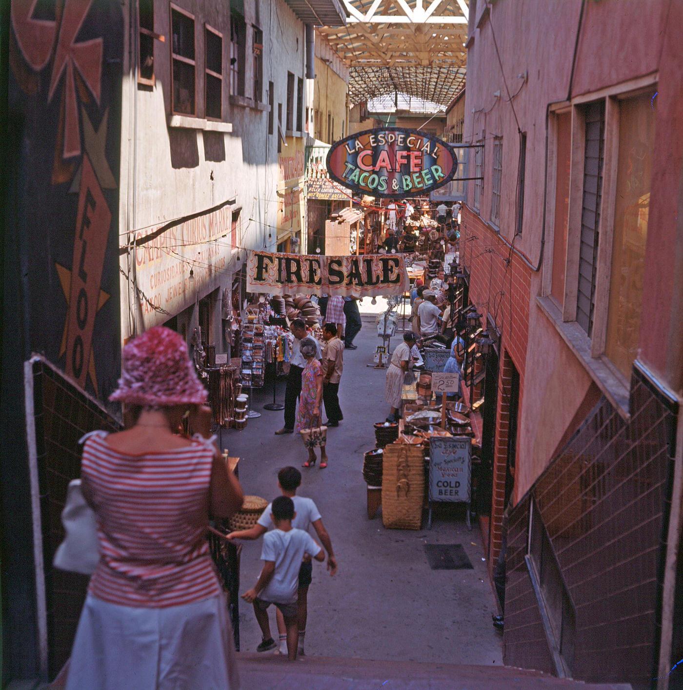View of a along a covered shopping arcade, Tijuana, Mexico, August 1963.