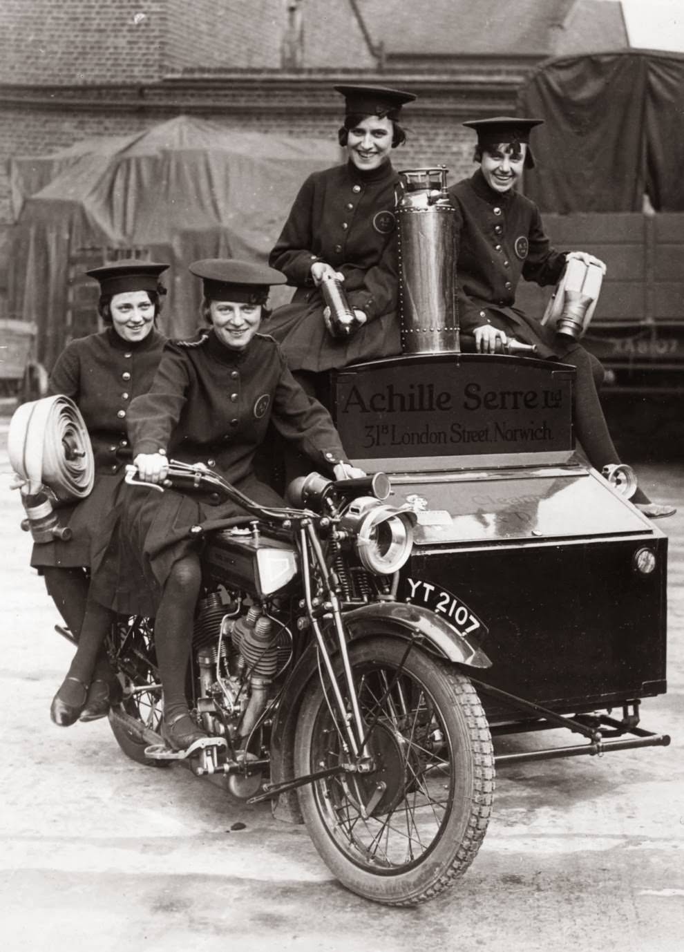 Women of achille serre ltd’s private fire brigade setting off on their motorcycle and sidecar to compete in the london private fire brigades’ tournament, 1925.