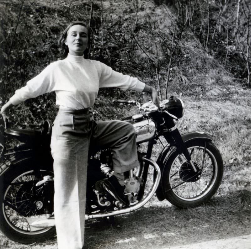 A young lady enthusiastically posing with an nsu konsul in the countryside, circa 1950s.