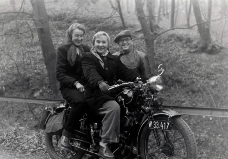 A company of three cheerfully posing with a puch 250 t in an autumnal forest. The bike is registered in the city of vienna, circa 1955.