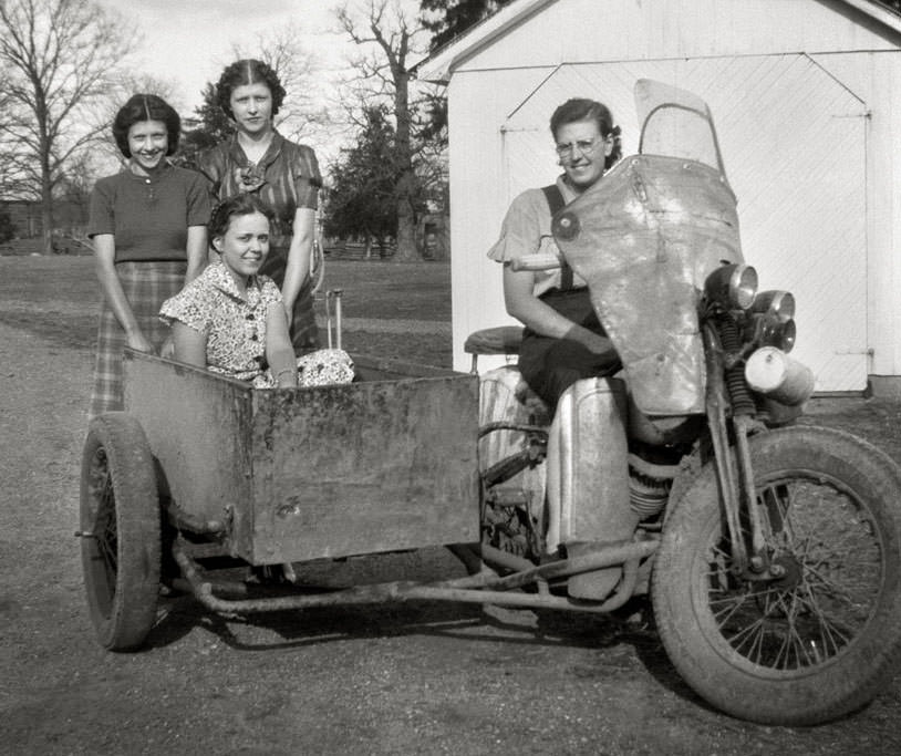 Ladies posing with a vintage sidecar motocycle