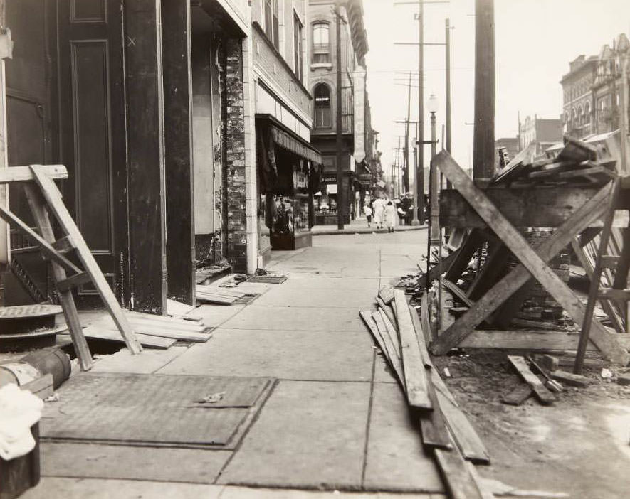 Sidewalk repair on South Broadway near its intersection with Lafayette. The sign and storefront for the Heitmeyer Drug Co. can be seen in the background, 1930