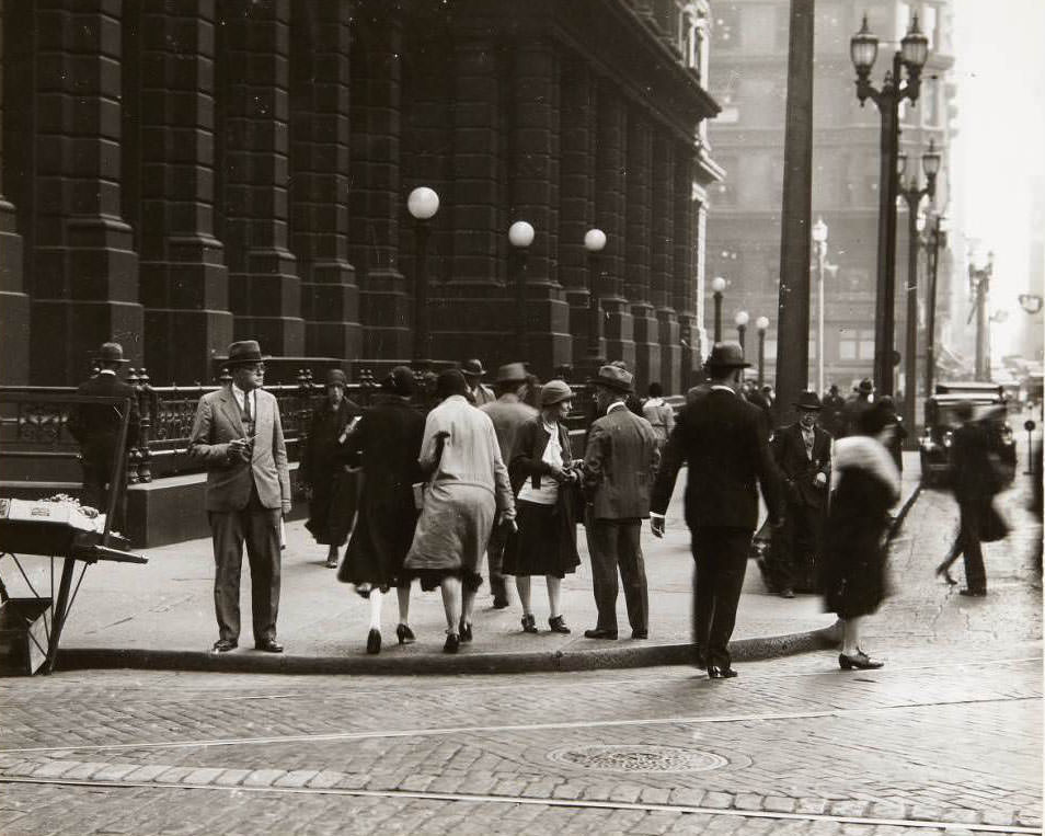 Pedestrians crossing Olive St. at Ninth St. with the Old Post Office building visible in the background, 1930