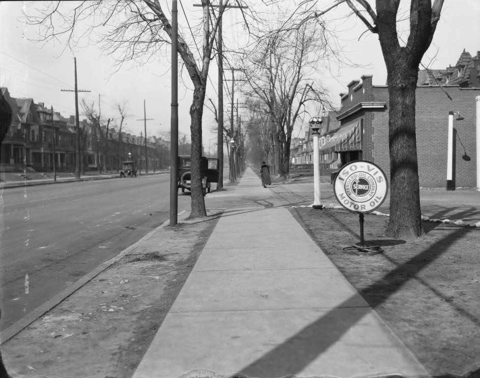 View of sidewalk and residential street. Standard Oil filling station sign is visible. 4403 Laclede, 1930