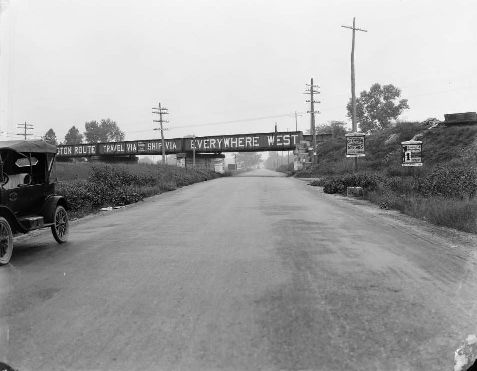 View of railroad overpass on Riverview Blvd. with "Burlington Route, Travel Via, Ship Via, Everywhere West" painted on it, 1930