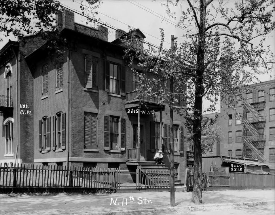 View of a large home on North 11th Street between Clinton Place and Monroe with a man sitting on the porch, 1930