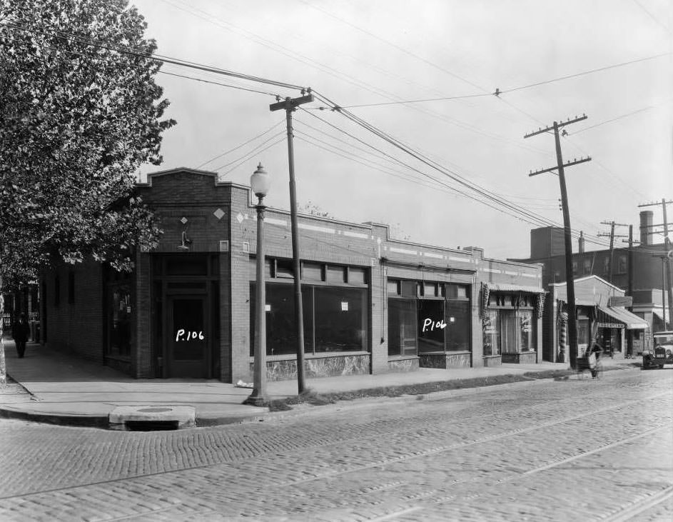 View of northeast corner of W. Florissant and Obear Ave., with the Nancy Shoppe tailor storefront visible, 1931