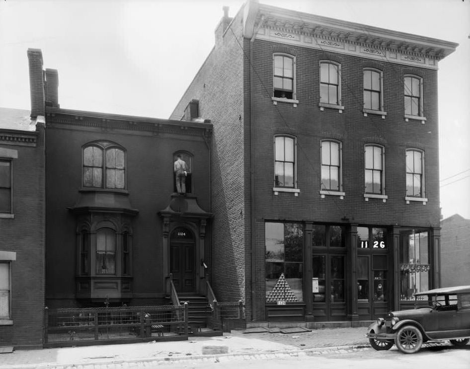 View of 1122-1126 Monroe near 12th, with a grocery store on the first floor of the three-story corner building, 1931