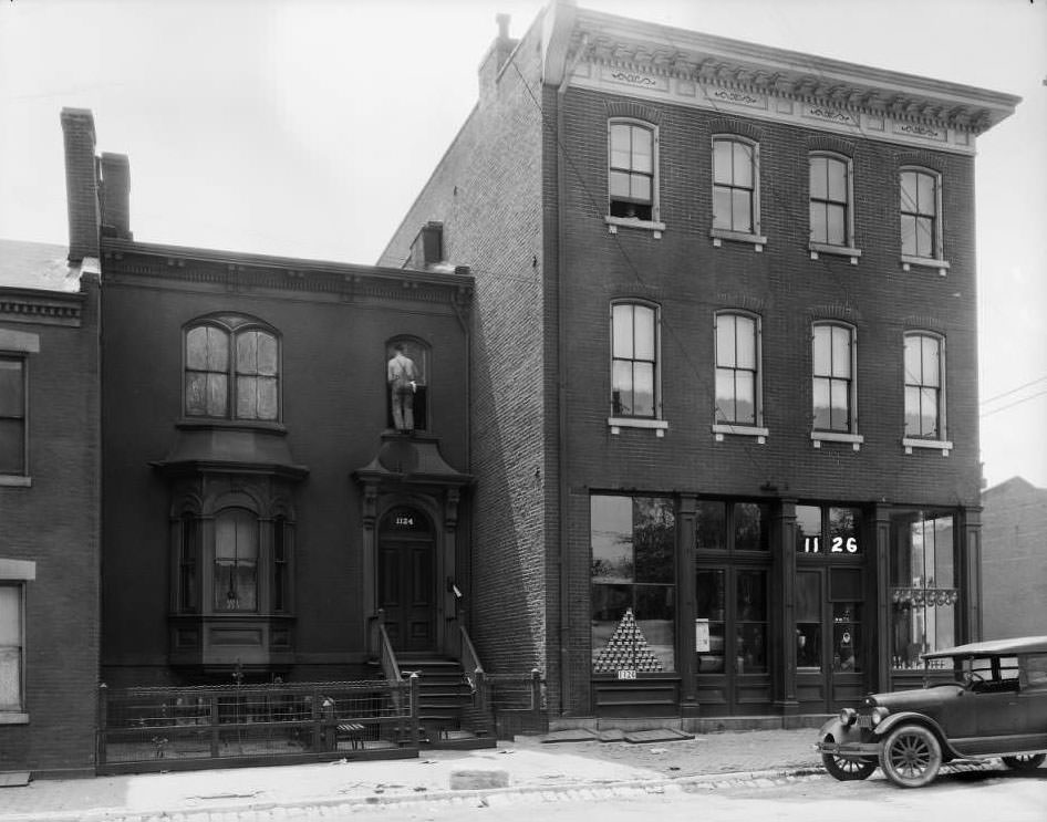 View of 1122-1126 Monroe near 12th, with a grocery store on the first floor of the three-story corner building, 1931