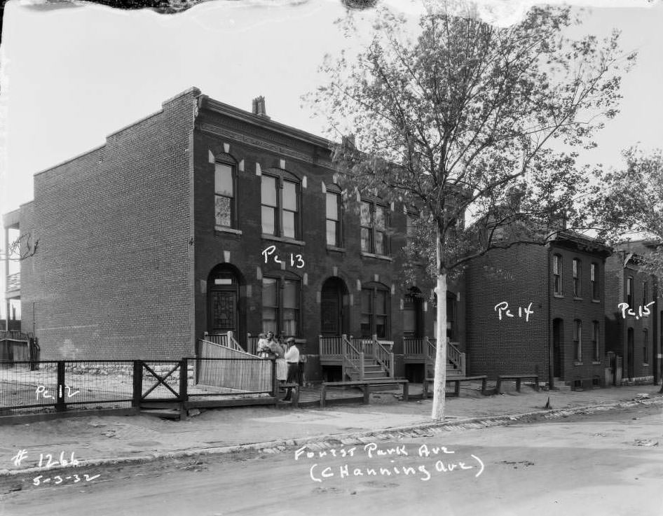 View of an African-American family standing in front of a multi-family brick dwelling on Forest Park Ave, 1932