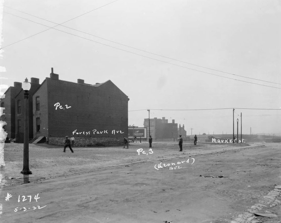 View of young men playing sport in vacant lot, and nearby flounder-style houses, Leonard Ave., Market St., Forest Park Ave., 1932.