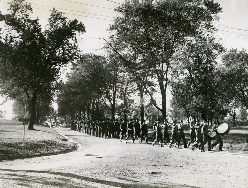 Army men led by bass drummers of marching band, 1930.