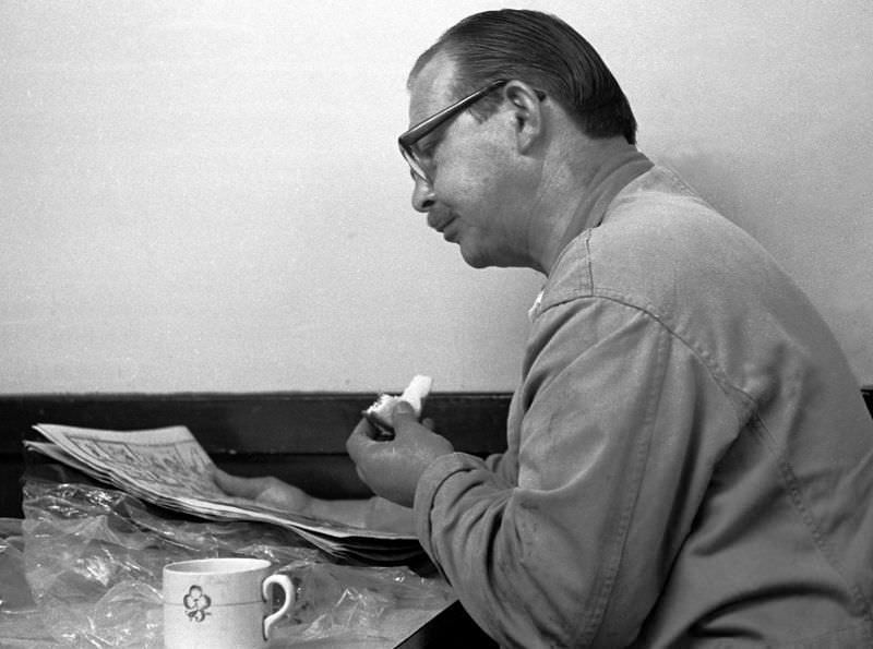 Driver, sandwich and newspaper, Paignton bus station, 1970