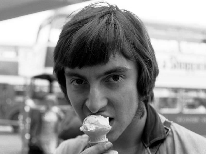 Conductor with ice cream, Paignton bus station, 1970