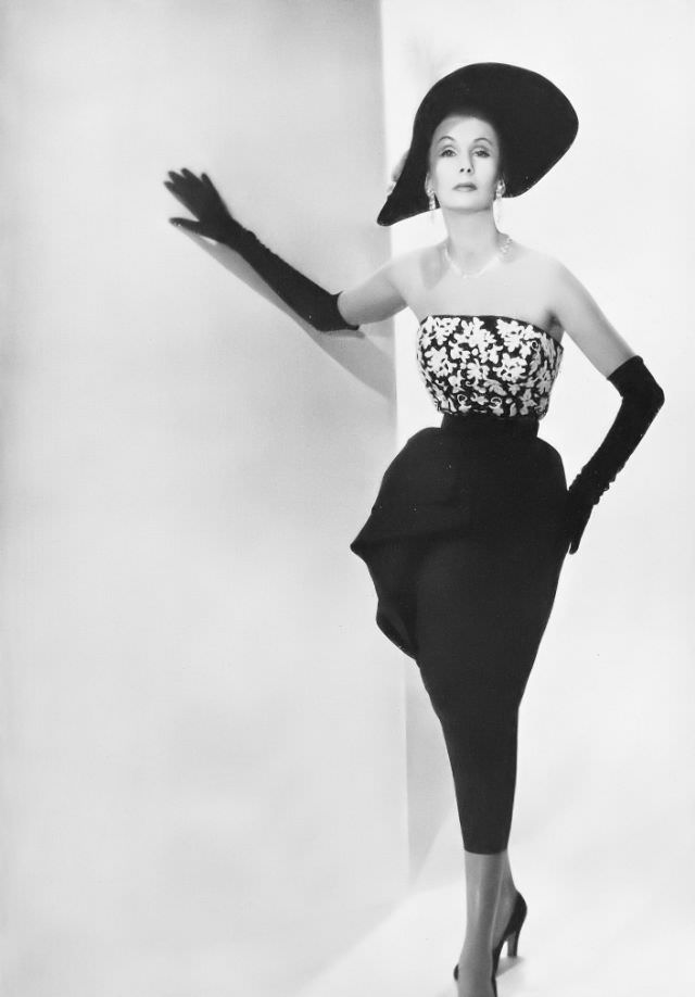 Barbara Goalen in white-sequined embroidered bodice with jet black accents and black faille skirt worn with black velvet hat and gloves, all from Debenham & Freebody, 1950.