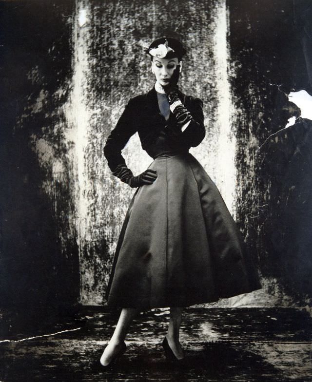 Barbara Goalen in short black velvet jacket over faille dress with bell skirt by Marcus at Harvey Nichols, 1951.
