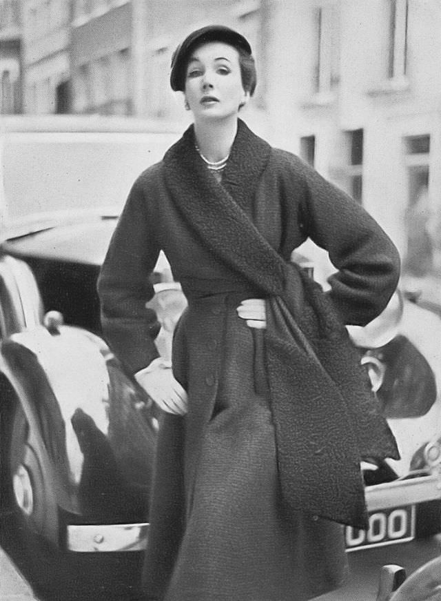 Barbara Goalen in liquorice-colored ribbed bouclé coat with a collar and cross-over sash of black Persian lamb by Digby Morton, hat by Rudolf, 1952.