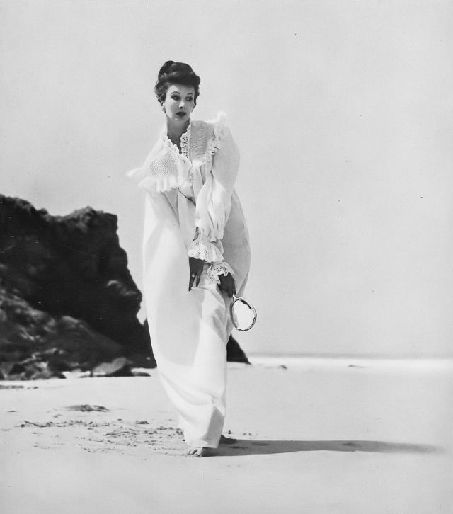 Barbara Goalen in straight-laced nightdress in fine, white lawn, softened with tucks and frills of broderie Anglaise by Janet West, 1952.