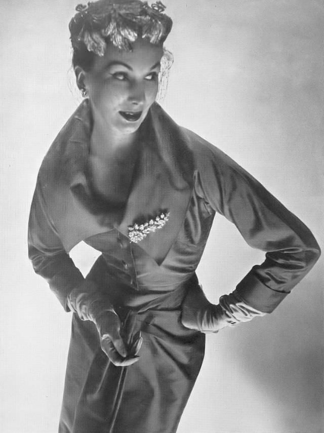 Barbara Goalen in close-fitting jacket with the look of a bodice over a halter-neck dress by Dorville, 1953.