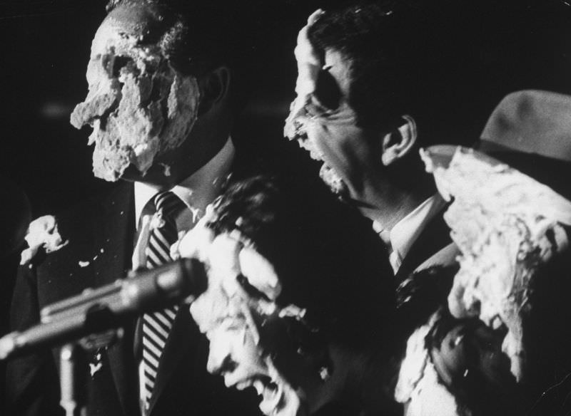 Comedian Bob Hope with Soupy Sales and Shirley MacLaine, their faces covered with remnants of cream pies, 1962.