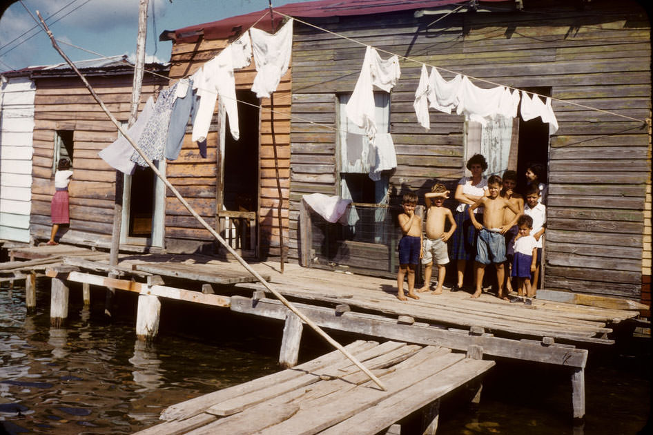 Children, laundry in houses built over water
