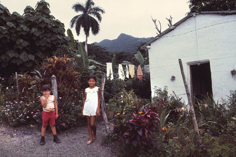 Farmers home and two young girls in their garden, Cuba, 1976