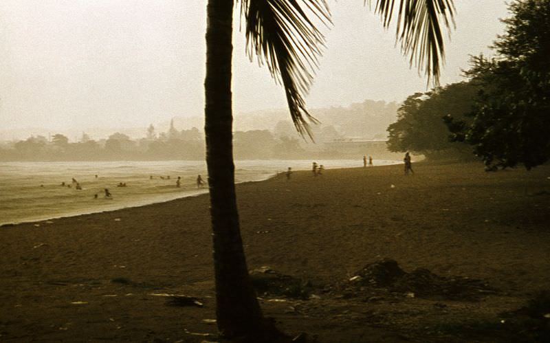 People bathing in the sea and children running while the wind announces the arrival of a storm, Cuba, 1976