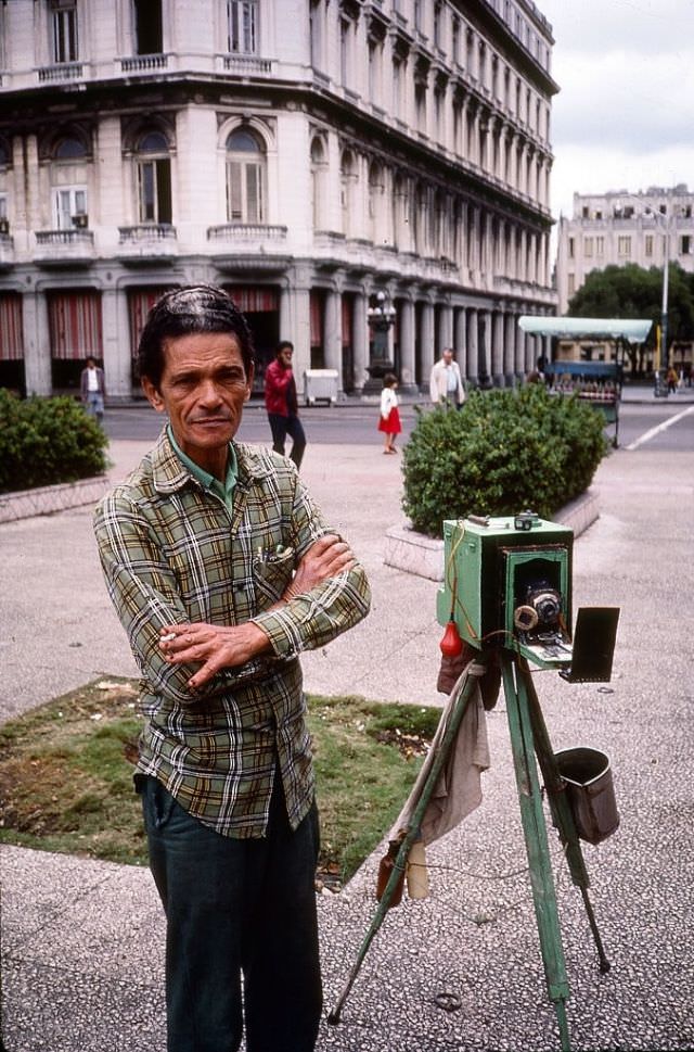 Portrait of a street photographer, beside his tripod and camera, near the Plaza de la Revolucion, Havana.