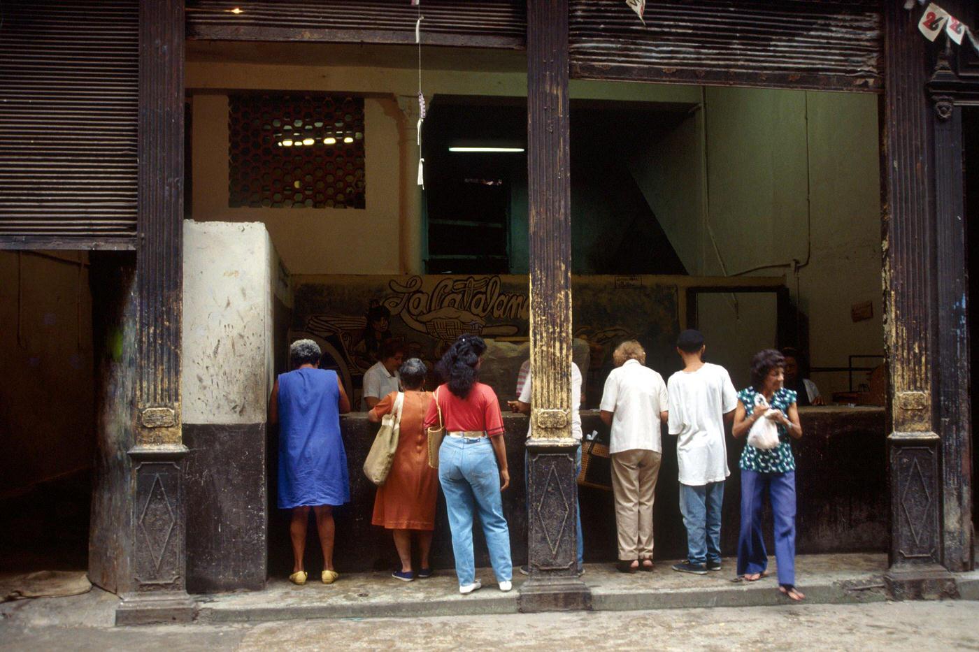 Cuban men and women queuing in front of a public shop using the ration book in Cuba, 1990.