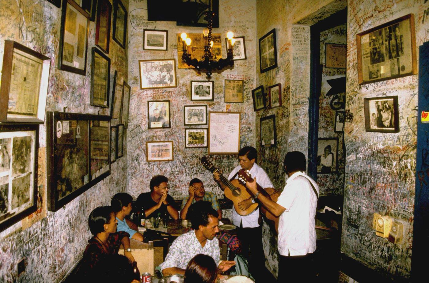 Two Cuban musicians playing guitar at the bar restaurant La Bodeguita del Medio in Havana, Cuba, 1990.