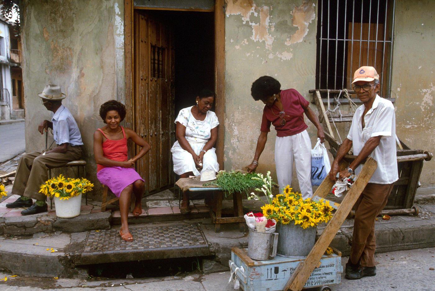 Cuban people selling flowers at the entrance of their house, Cuba, 1990.