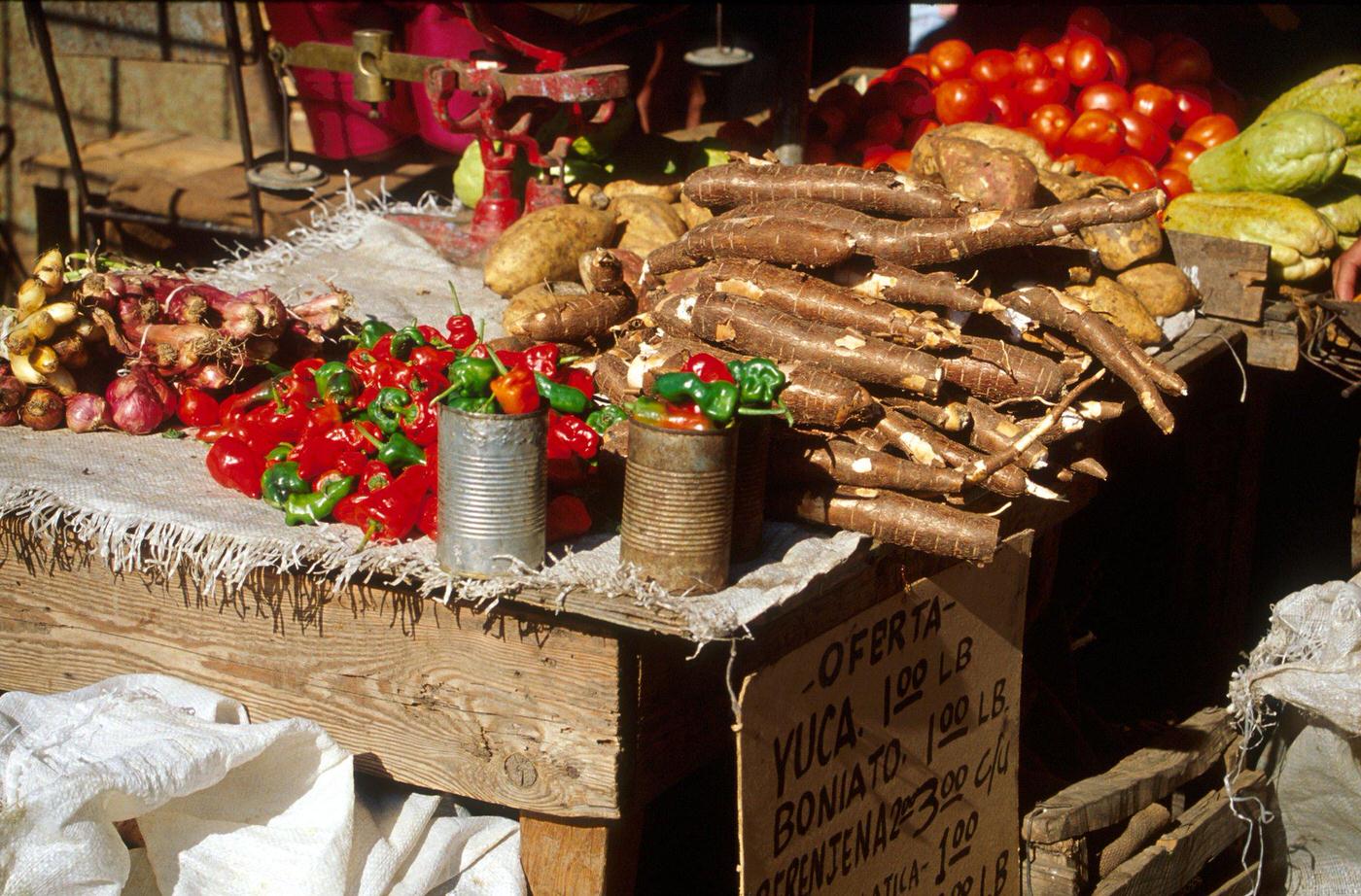 Food market in Santiago de Cuba selling yucca, sweet potatoes, chilies, and vegetables, 1990s.