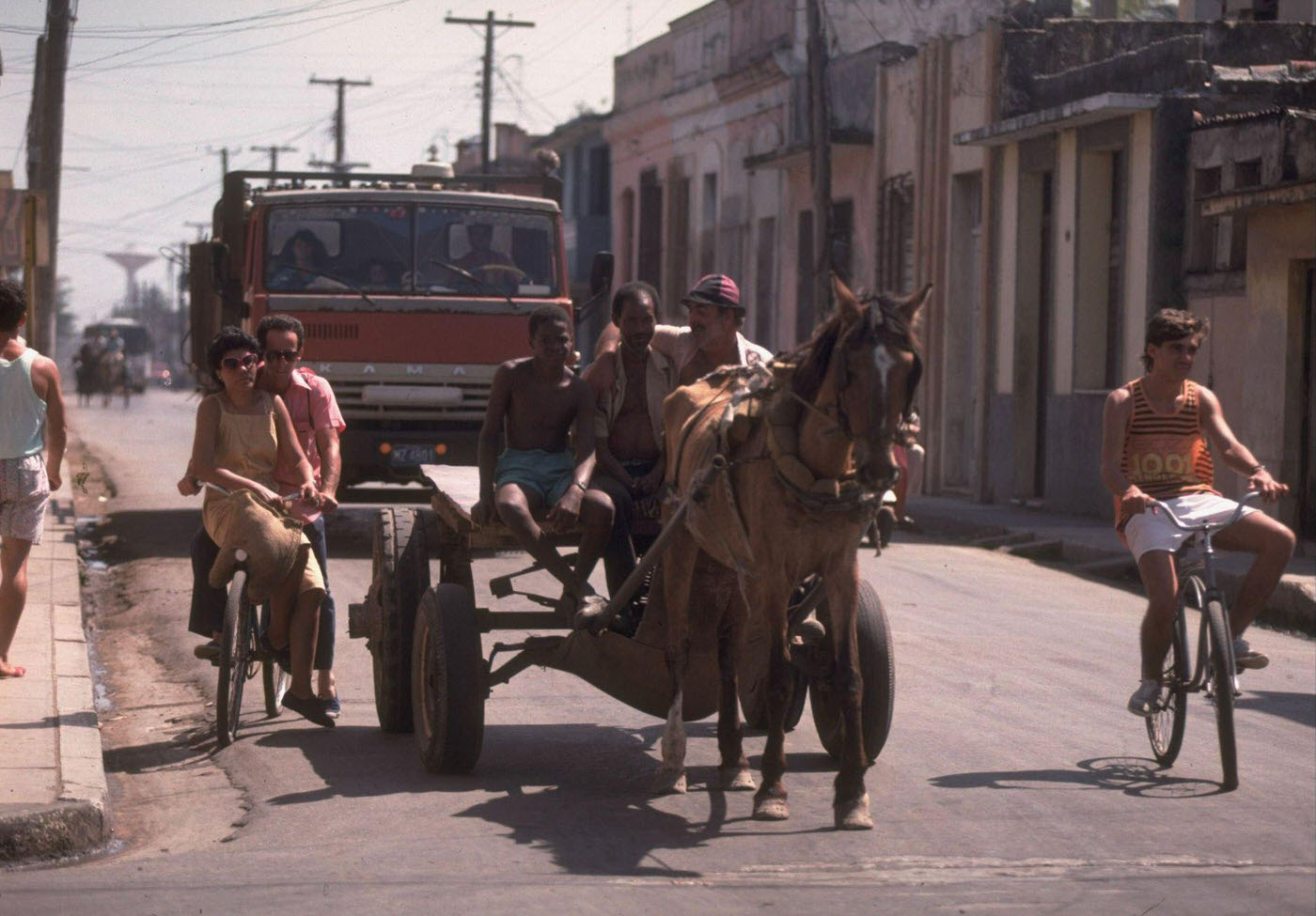 Bicyclists and a horse-drawn cart leading vehicular traffic in gasoline-conservation-minded Havana, Cuba.