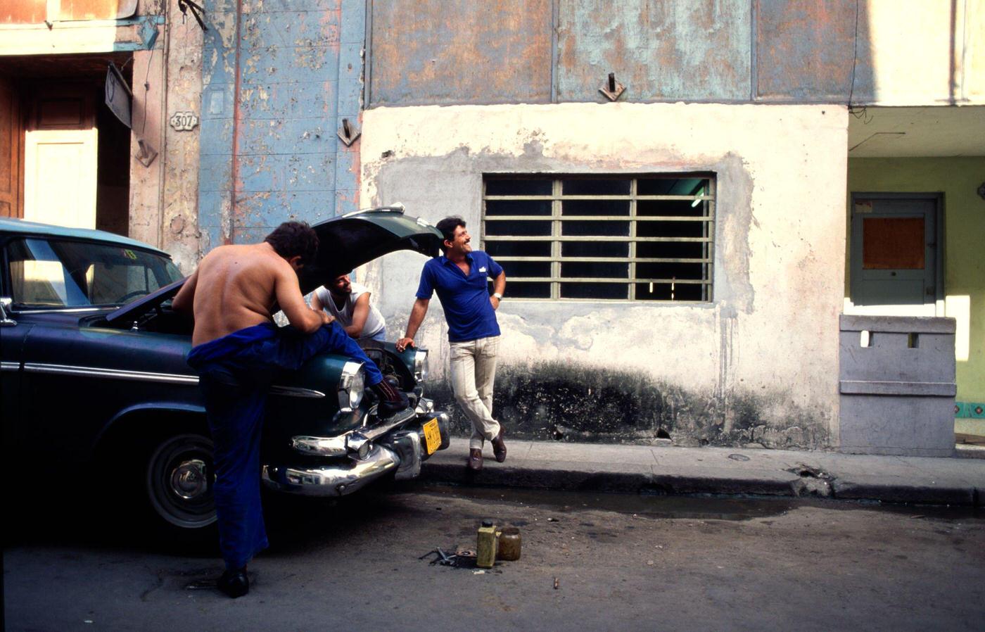 Cuban men trying to fix a 1950's American car in downtown Havana, Cuba, 1991.
