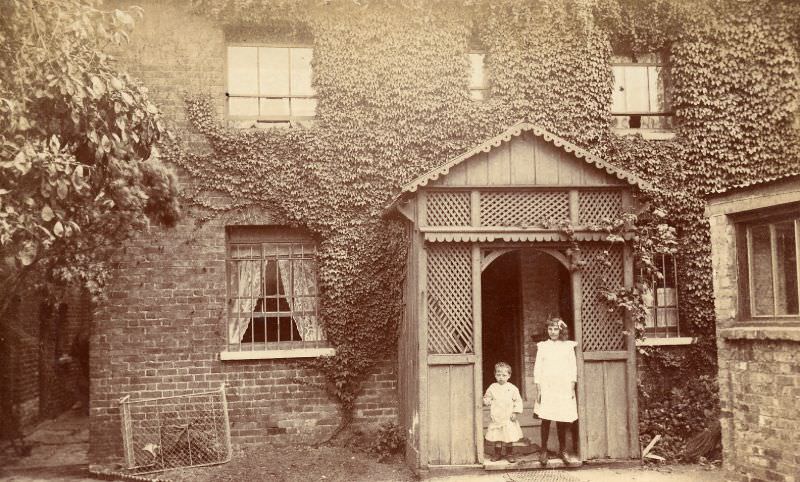 Edwardian children stand in nicely made decorative timber porch