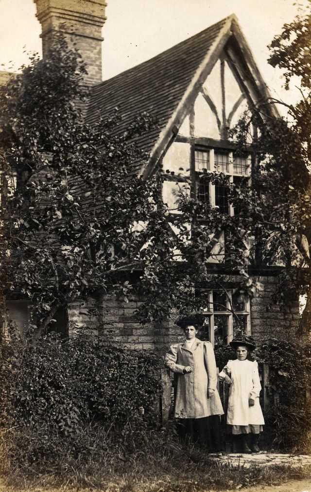 Mother and daughter in front of timber-framed house